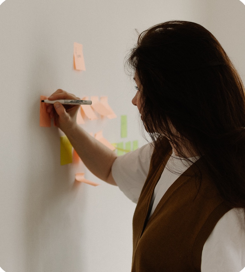 Karina sketching a flow with sticky notes on a wall