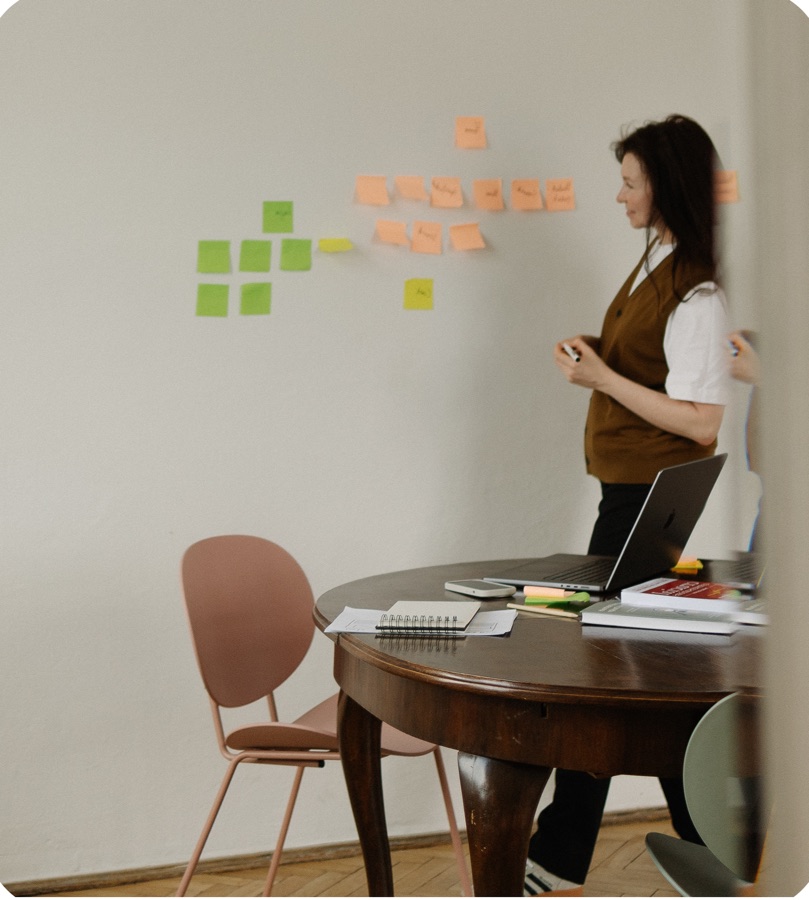 Karina mapping sticky notes on a wall during a working session